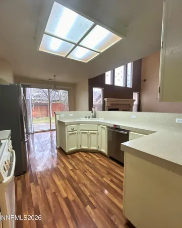 a kitchen with a sink a stove top oven and cabinetry