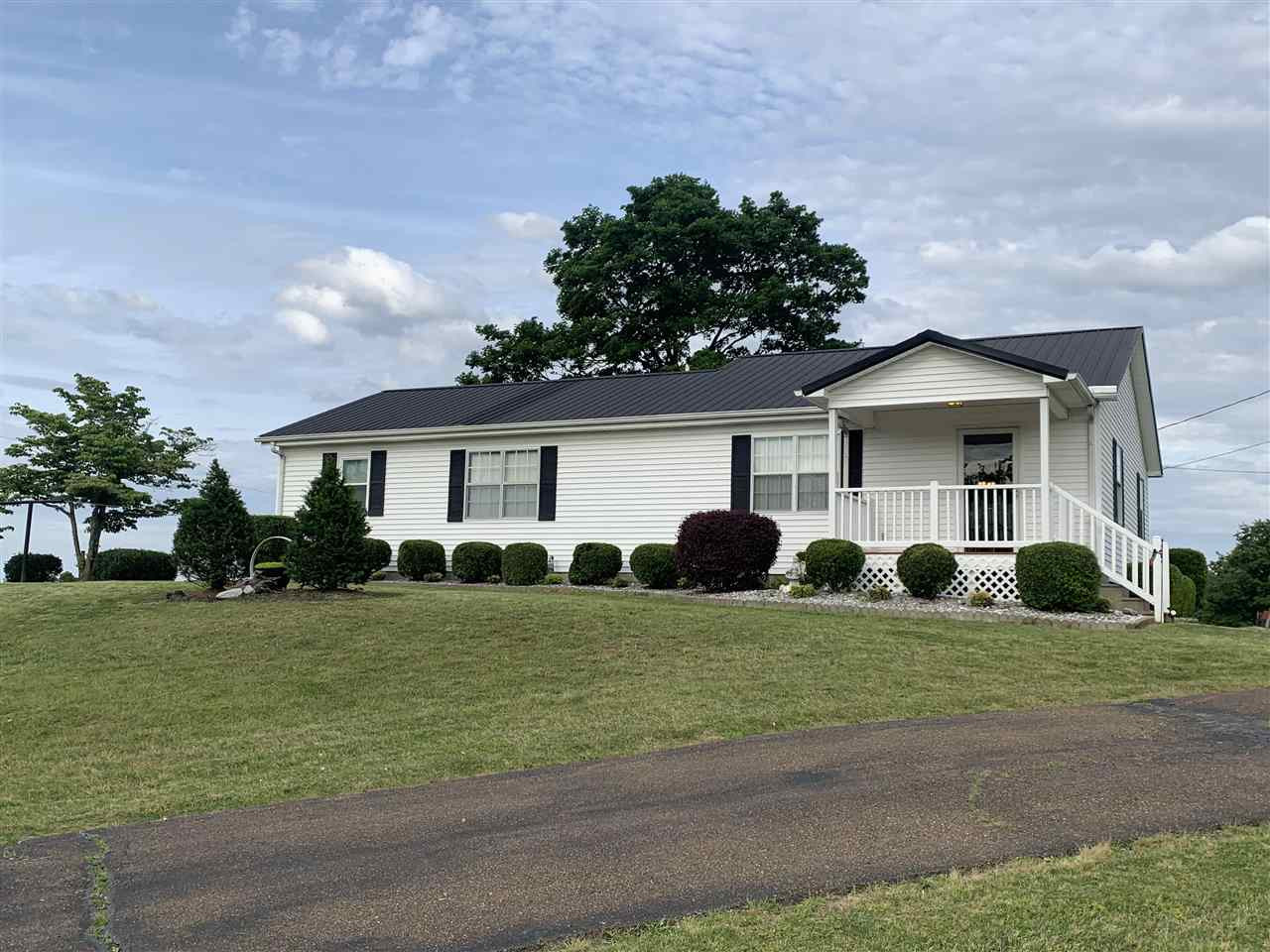 a front view of a house with a garden and trees