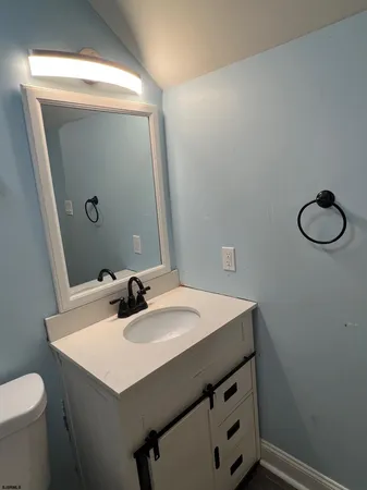 a bathroom with a sink a toilet and mirror