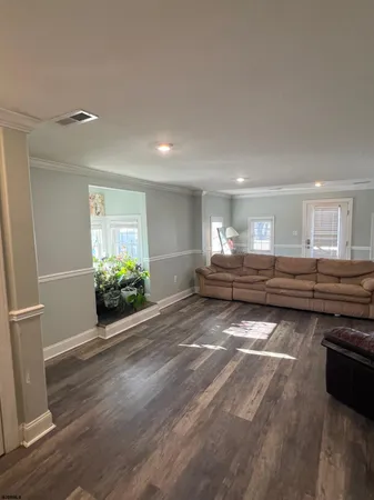 a room with lots of wooden furniture and a potted plant