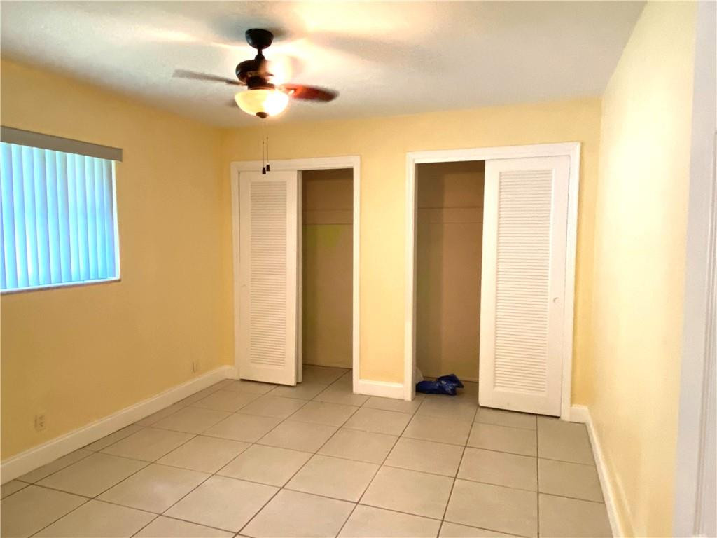 5019 Northwest 49th Road Tamarac, FL 33319 - Photo 22 of 25 a view of an empty room with window and a ceiling fan