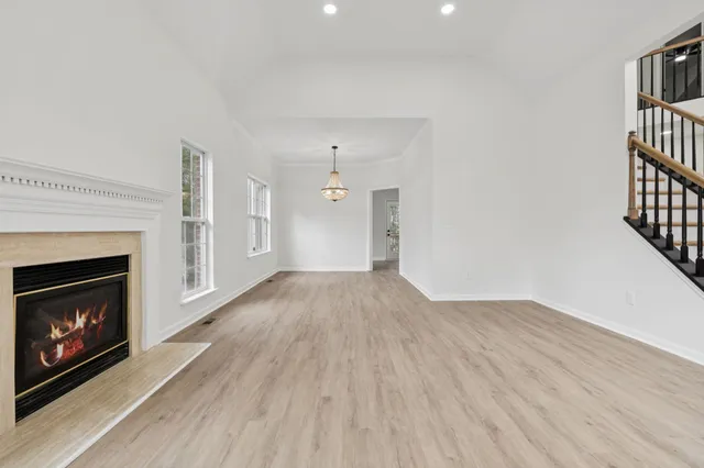 wooden floor fireplace and windows in an empty room