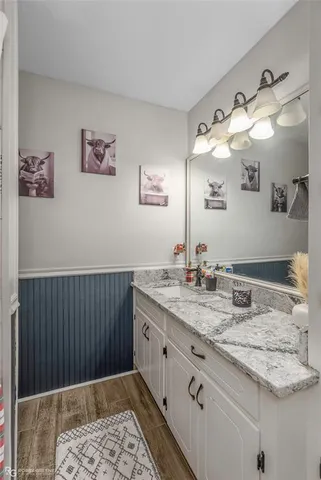 a bathroom with a granite countertop sink a mirror and vanity