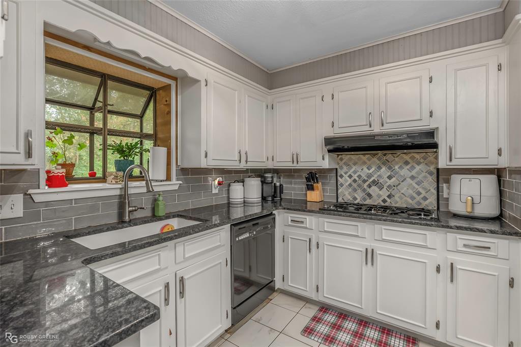 3237 Pinehaven Lane Haughton, LA 71037 - Photo 5 of 16 a kitchen with stainless steel appliances granite countertop a sink a stove and white cabinets