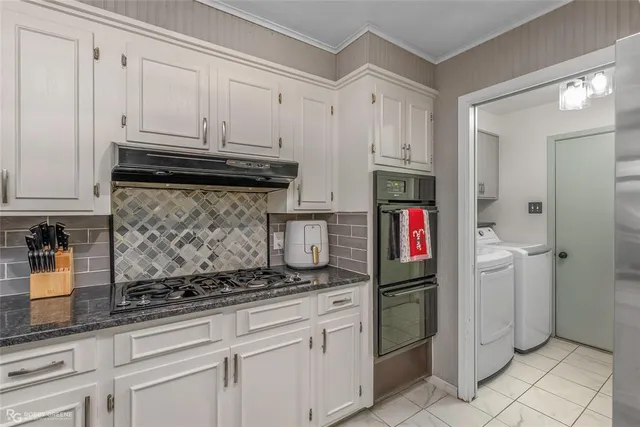 a kitchen with stainless steel appliances granite countertop a refrigerator and a stove