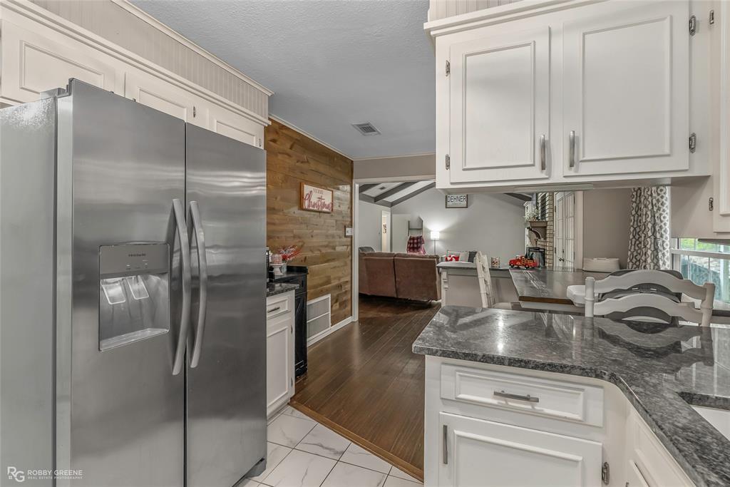 3237 Pinehaven Lane Haughton, LA 71037 - Photo 8 of 16 a kitchen with stainless steel appliances granite countertop a refrigerator a stove and a sink with wooden floor