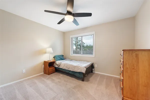 a bedroom with a bed and a ceiling fan