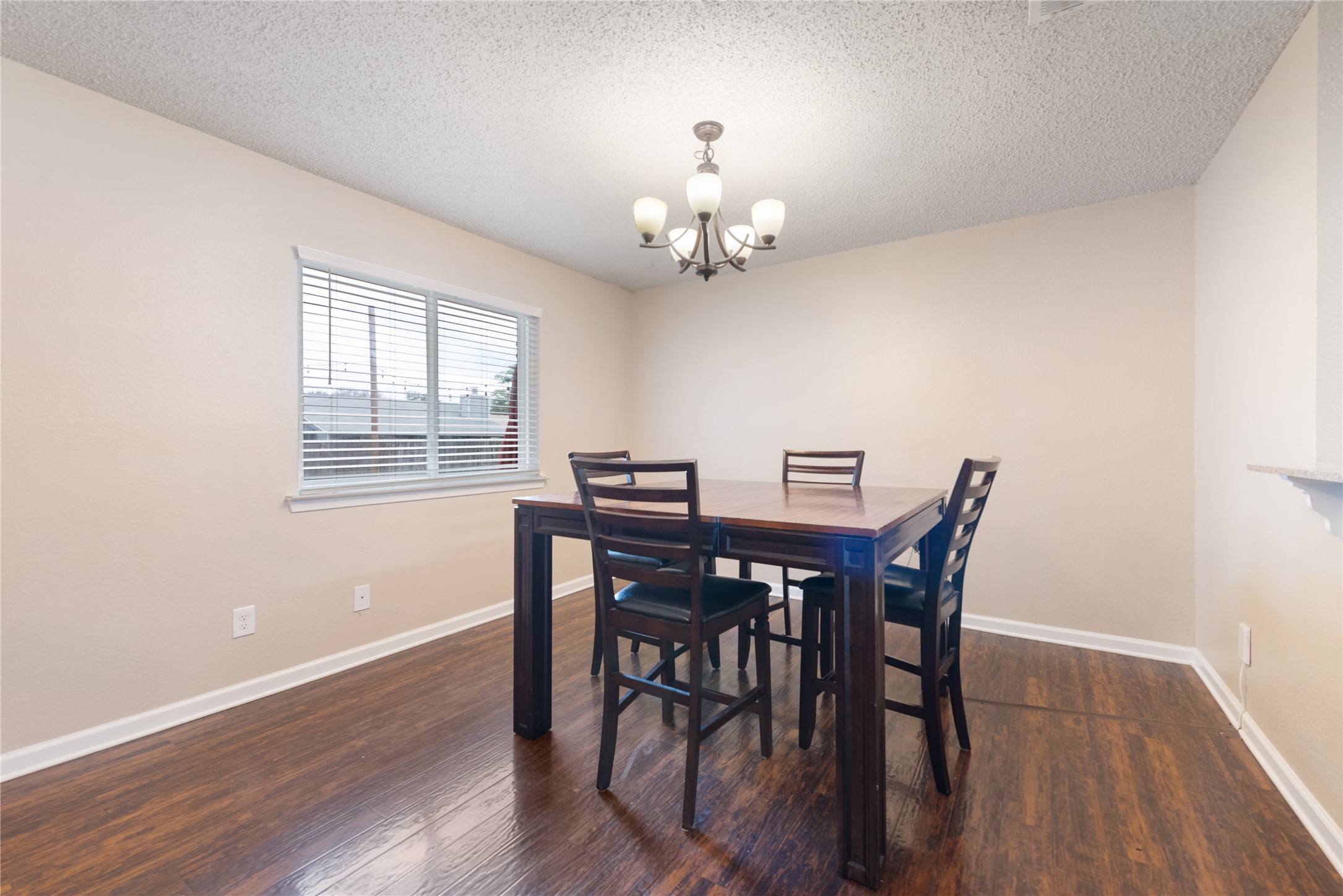 3608 Cookstown Drive Austin, TX 78759 - Photo 16 of 22 a view of a dining room with furniture a chandelier and wooden floor