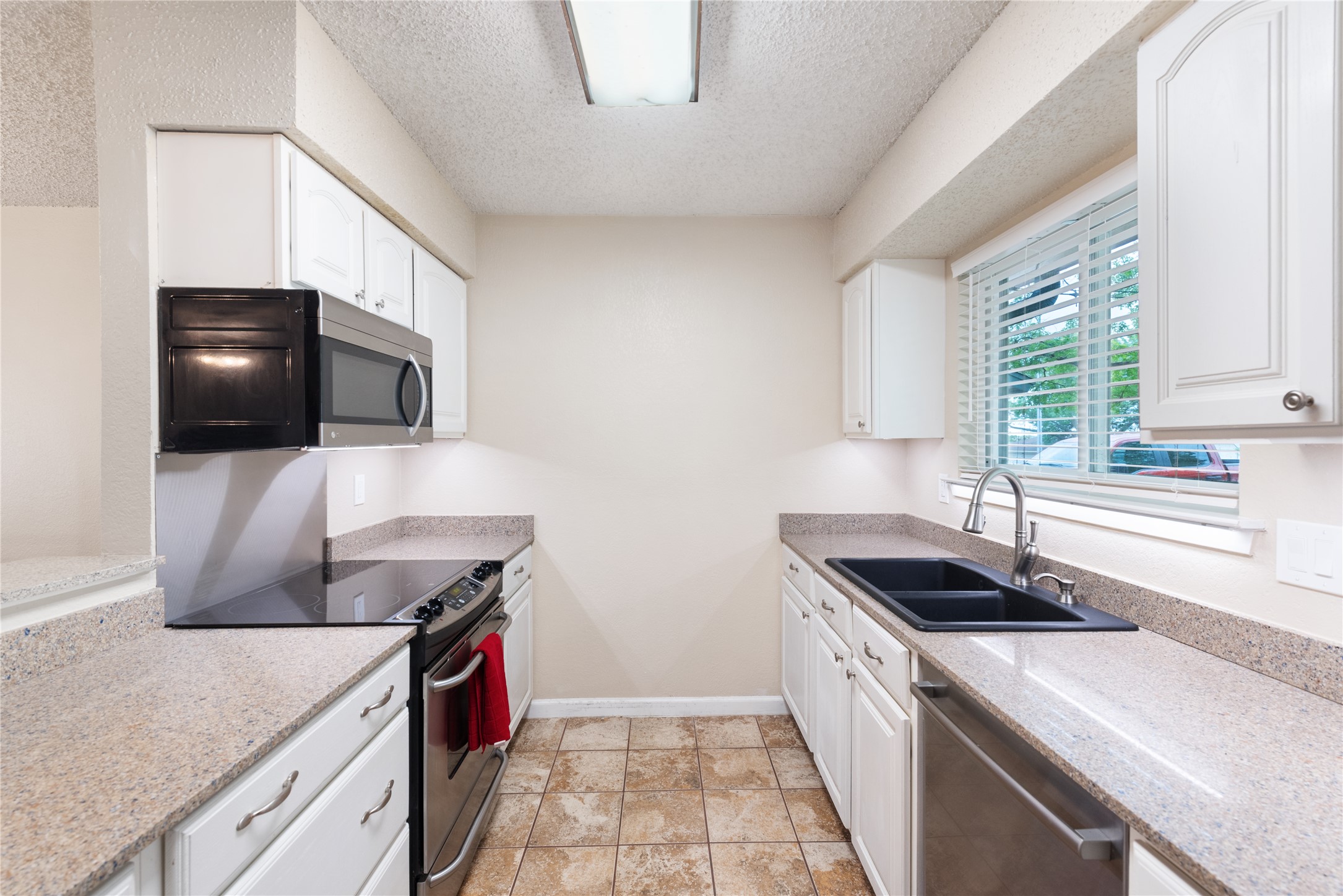 3608 Cookstown Drive Austin, TX 78759 - Photo 4 of 22 a kitchen with stainless steel appliances a sink a stove a microwave a refrigerator and cabinets
