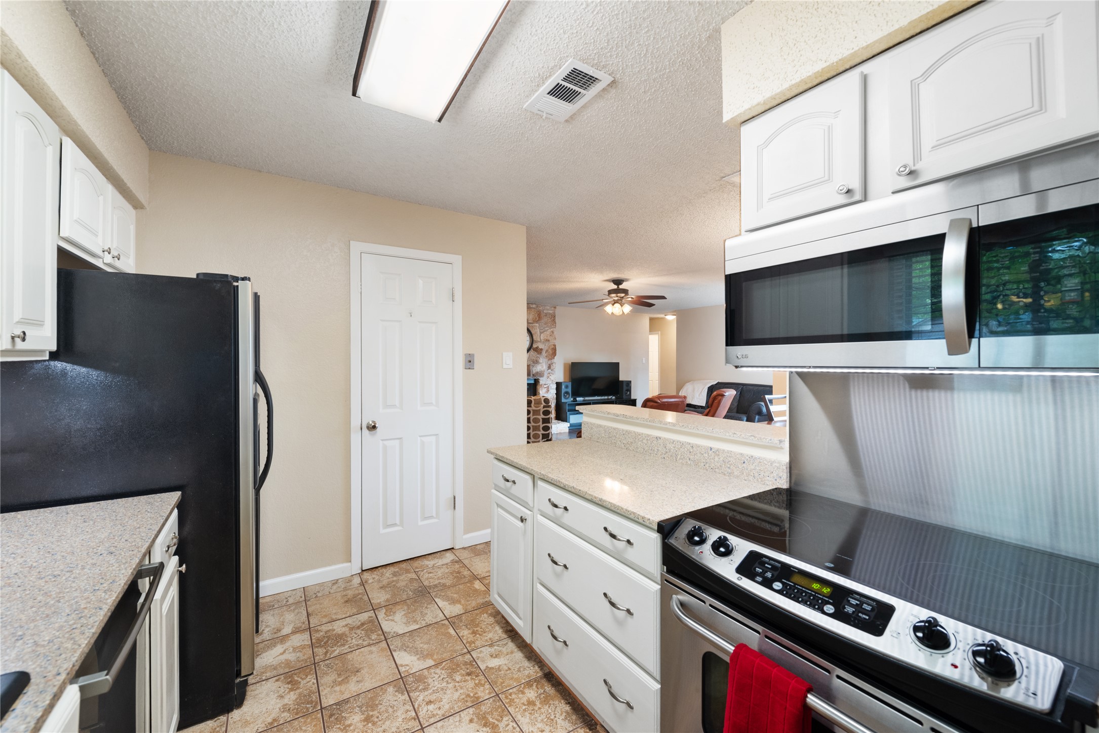 3608 Cookstown Drive Austin, TX 78759 - Photo 5 of 22 a kitchen with stainless steel appliances a stove a microwave and a refrigerator