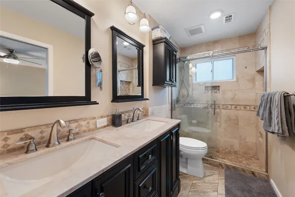 a bathroom with a granite countertop sink toilet and shower