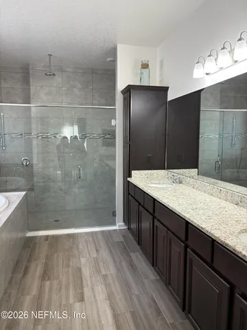 a bathroom with a granite countertop shower a sink and a mirror