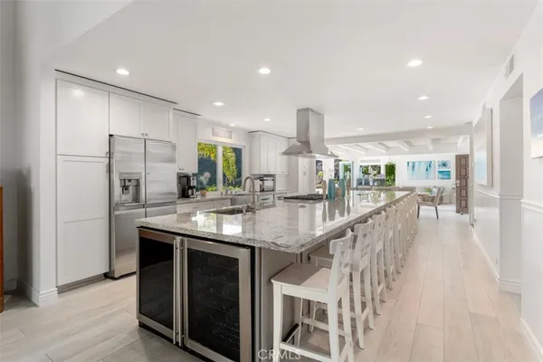 a kitchen with stainless steel appliances granite countertop a sink a stove a refrigerator and a oven with wooden floor