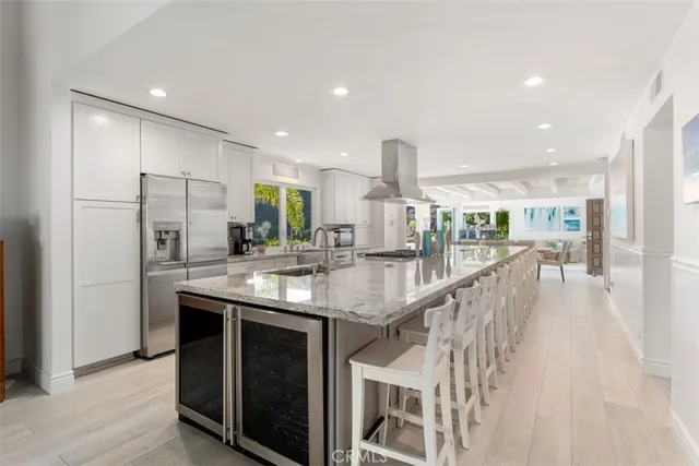 a kitchen with stainless steel appliances granite countertop a sink a stove a refrigerator and a oven with wooden floor