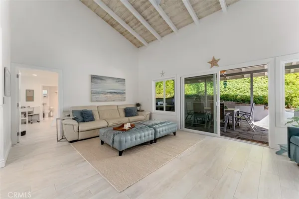 a living room with furniture and a large window with balcony view