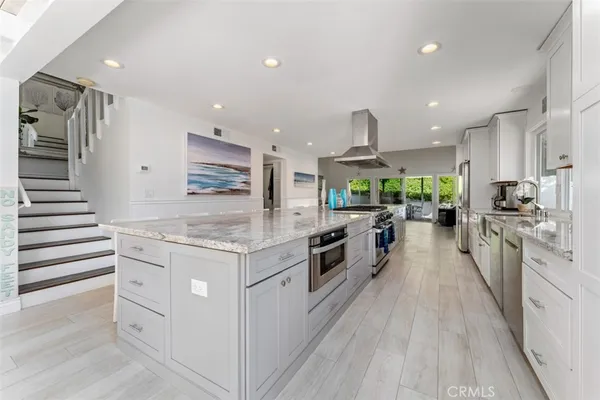 a kitchen with stainless steel appliances kitchen island granite countertop a stove and a sink