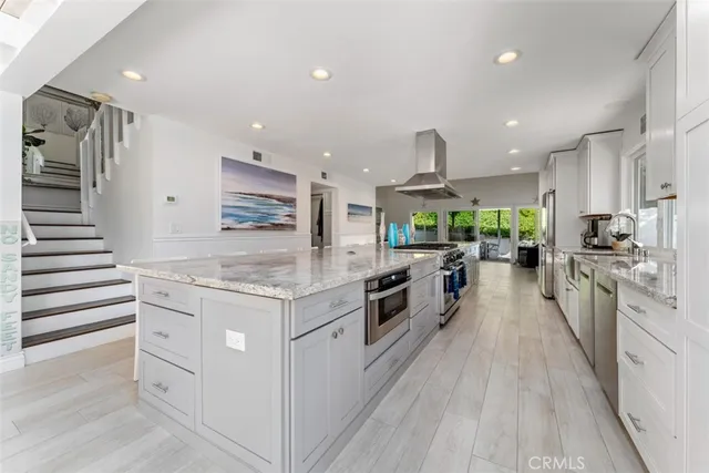 a kitchen with stainless steel appliances kitchen island granite countertop a stove and a sink