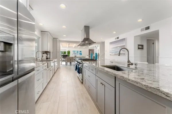 a large kitchen with stainless steel appliances lots of counter space and a sink