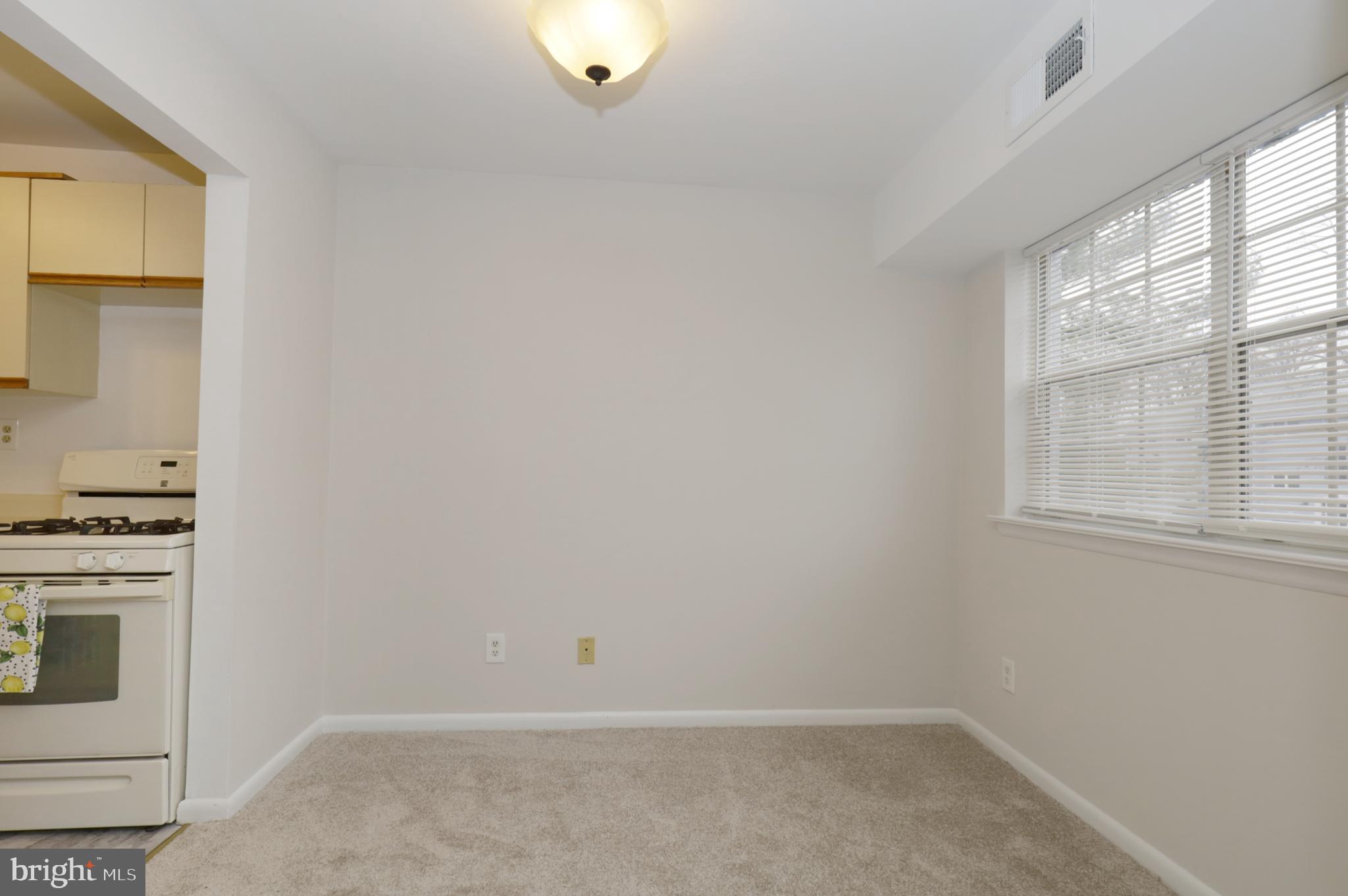 7093 Spring Garden Drive, Unit 101 Springfield, VA 22150 - Photo 11 of 23 a view of a kitchen with white cabinets and wooden floor