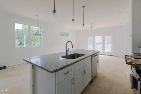 a kitchen with granite countertop a sink a window and appliances