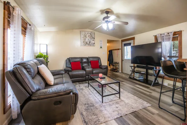 a living room with furniture a flat screen tv and a window