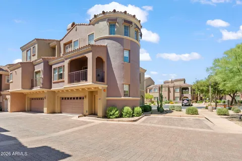 a front view of a multi story residential apartment building with garage and parking