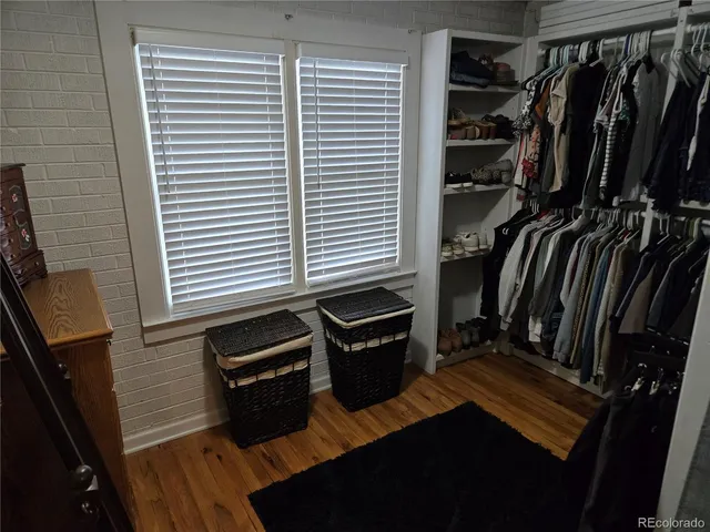 a view of walk in closet with clothes and shoes