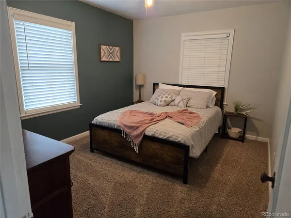 a large bed sitting in a bedroom next to a window