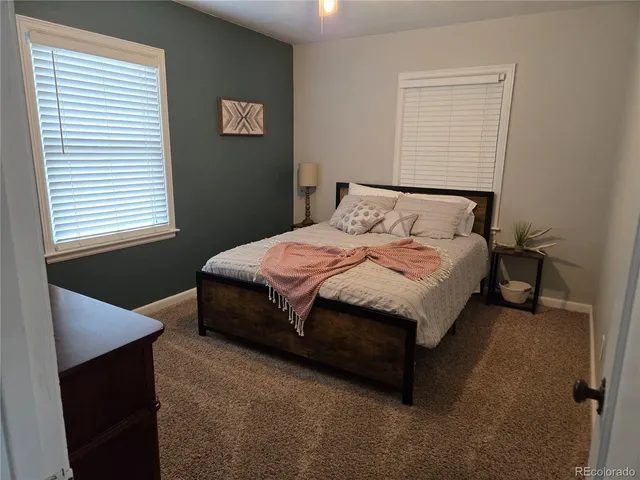 a large bed sitting in a bedroom next to a window