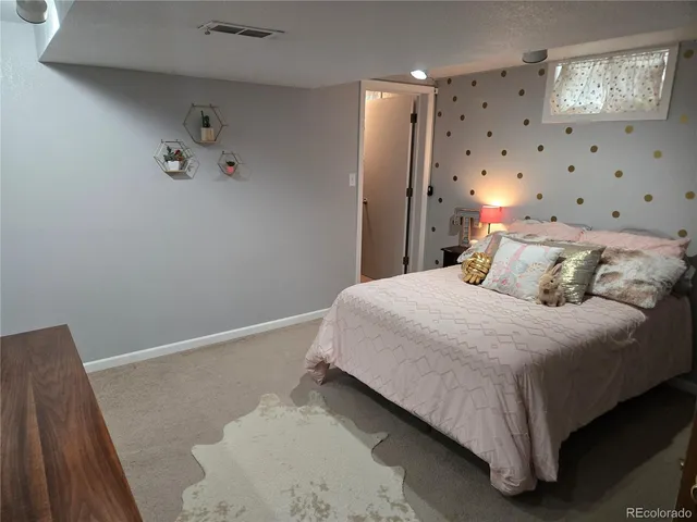 a bedroom with a bed and painting on the wall