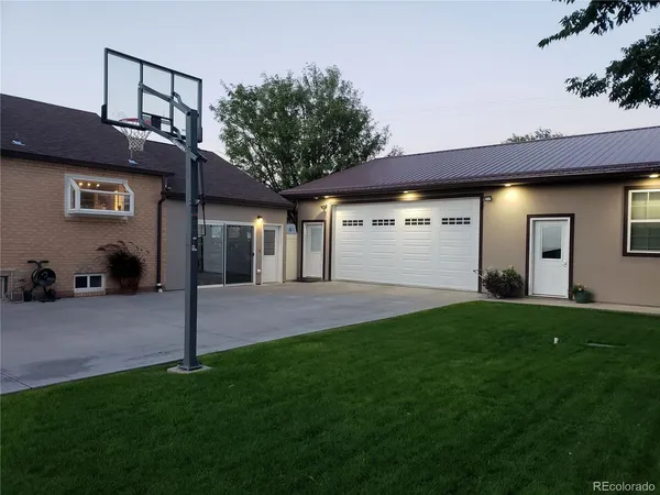 a view of a house with a big yard and large tree
