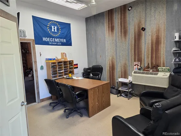 a view of a workspace with furniture and a window