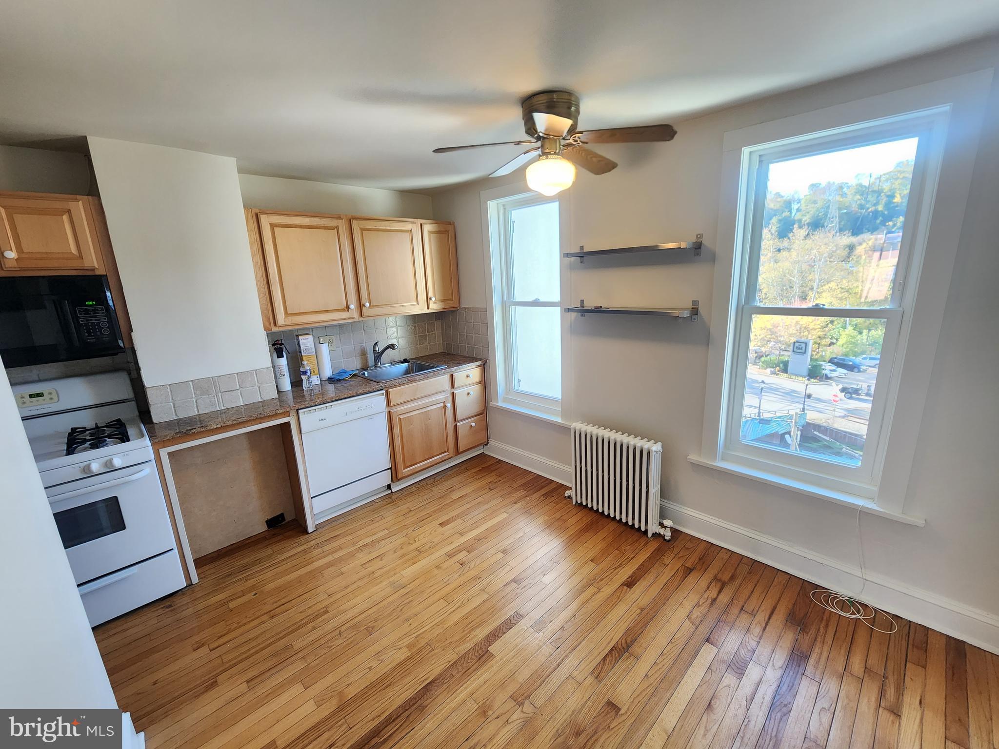 4322 Main Street, Unit 2 Philadelphia, PA 19127 - Photo 12 of 27 a kitchen with wooden floors and white cabinets