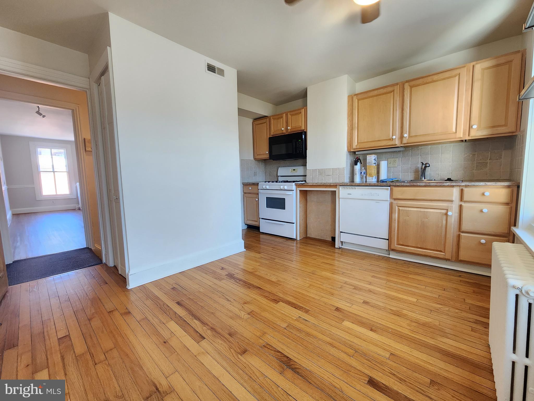 4322 Main Street, Unit 2 Philadelphia, PA 19127 - Photo 16 of 27 a kitchen with stainless steel appliances granite countertop a stove a sink dishwasher and a microwave oven with wooden floor