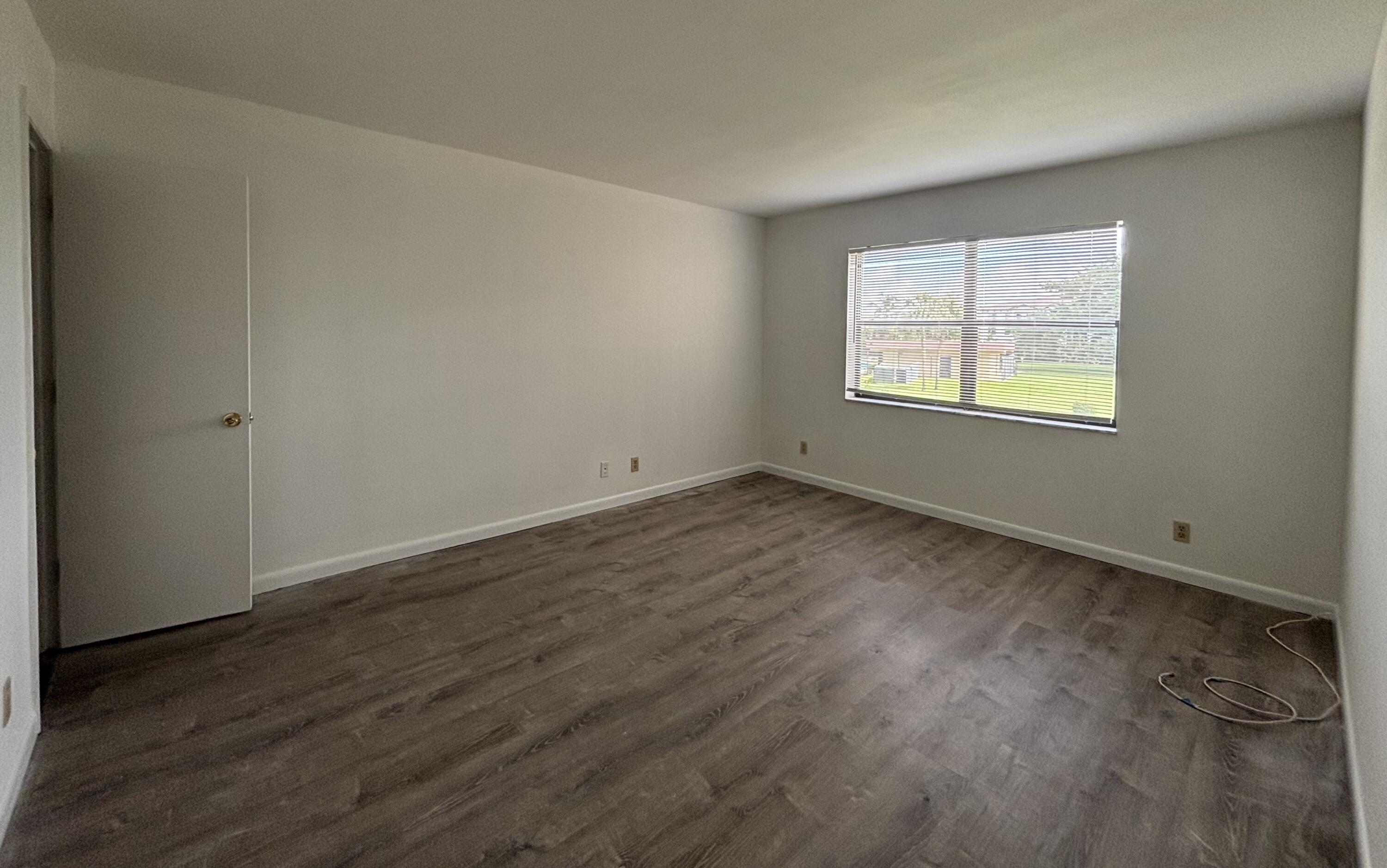 9355 Southwest 8th Street, Unit 216 Boca Raton, FL 33428 - Photo 12 of 19 an empty room with wooden floor and windows