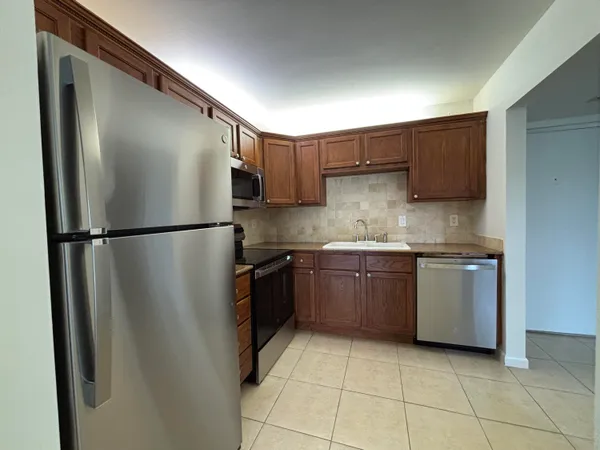 a kitchen with stainless steel appliances granite countertop a refrigerator and a sink