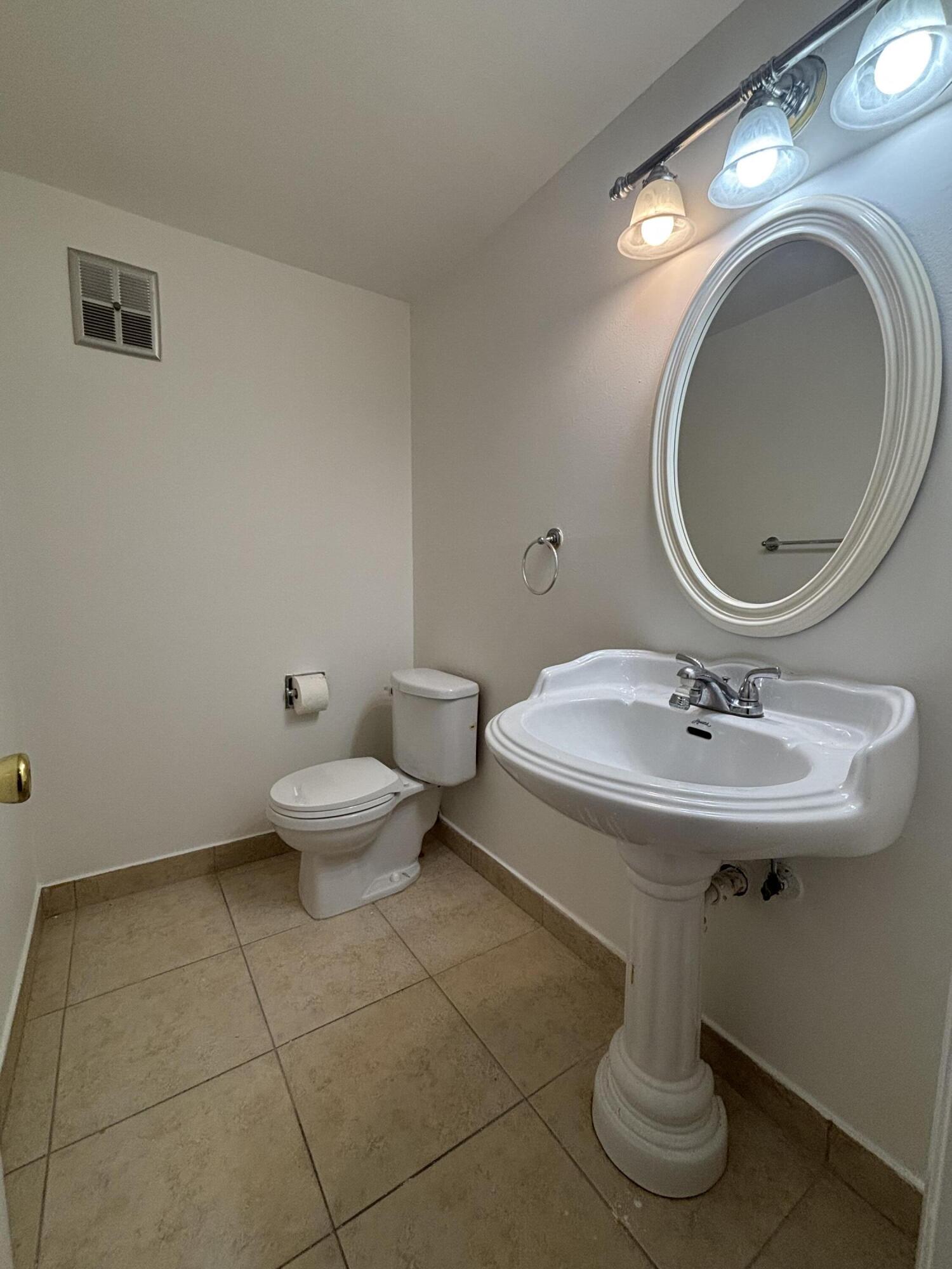 9355 Southwest 8th Street, Unit 216 Boca Raton, FL 33428 - Photo 10 of 19 a bathroom with a sink a toilet and a mirror