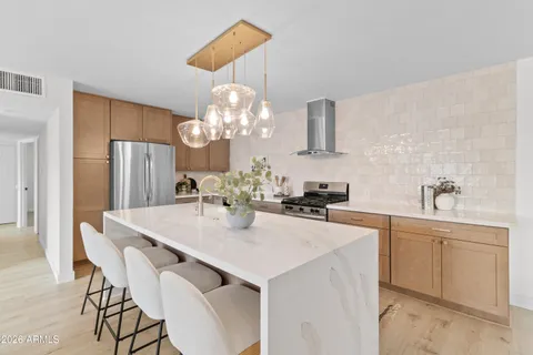 a kitchen with stainless steel appliances a dining table and chairs