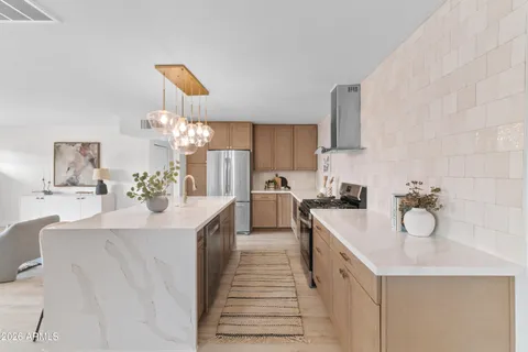 a view of a dining room kitchen island with stainless steel appliances a table and chairs