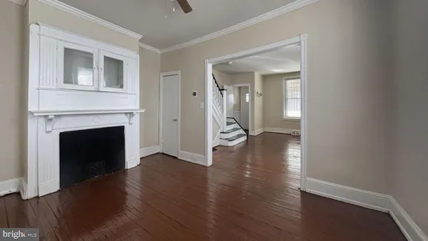a view of a livingroom with wooden floor and a fireplace