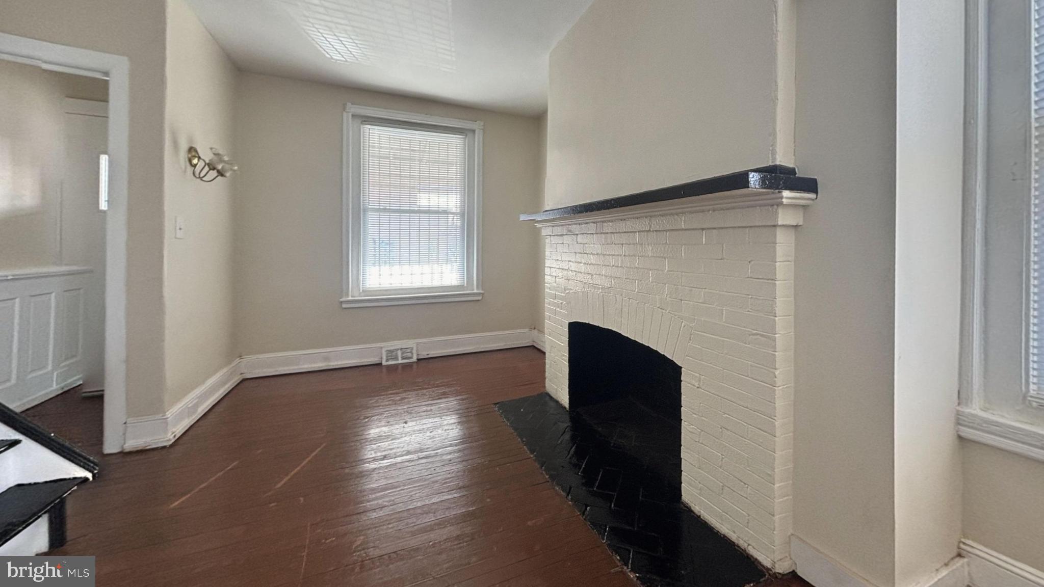 5471 Delancey Street Philadelphia, PA 19143 - Photo 4 of 9 a view of an empty room with wooden floor and a window