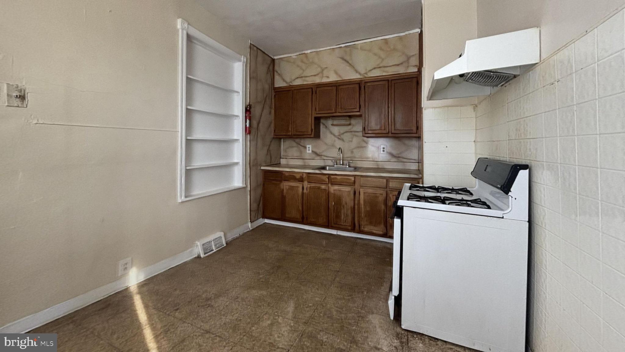 5471 Delancey Street Philadelphia, PA 19143 - Photo 5 of 9 a kitchen with stainless steel appliances granite countertop a sink and a stove with white countertops