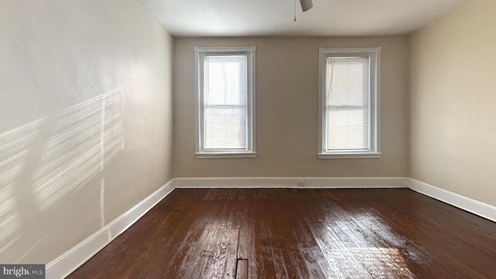 5471 Delancey Street Philadelphia, PA 19143 - Photo 7 of 9 an empty room with wooden floor and windows
