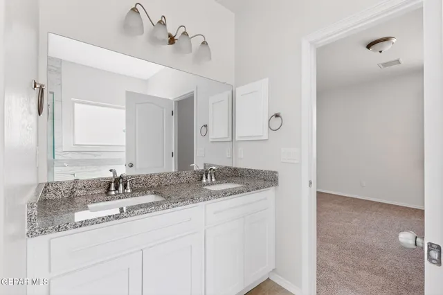 a bathroom with a granite countertop sink a toilet and a mirror