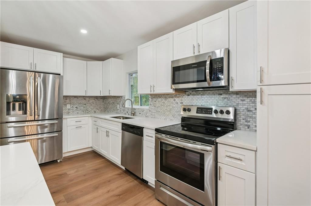24 McClure Road Temple, GA 30179 - Photo 13 of 41 a kitchen with cabinets stainless steel appliances and wooden floor