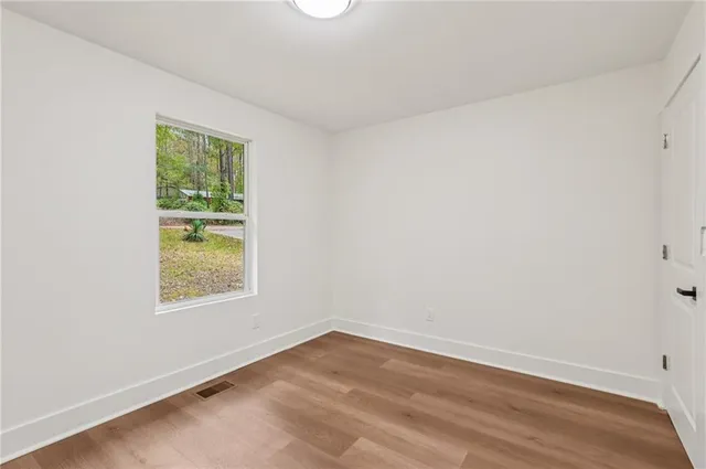 wooden floor in an empty room with a window