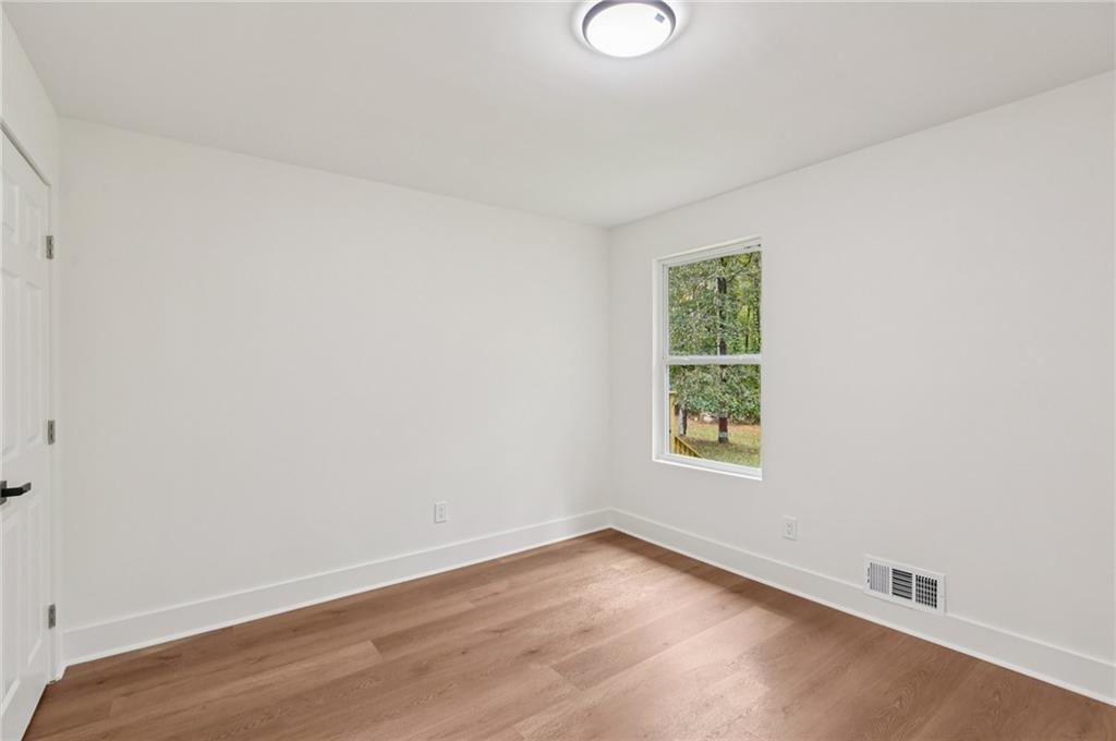 24 McClure Road Temple, GA 30179 - Photo 32 of 41 an empty room with wooden floor and windows