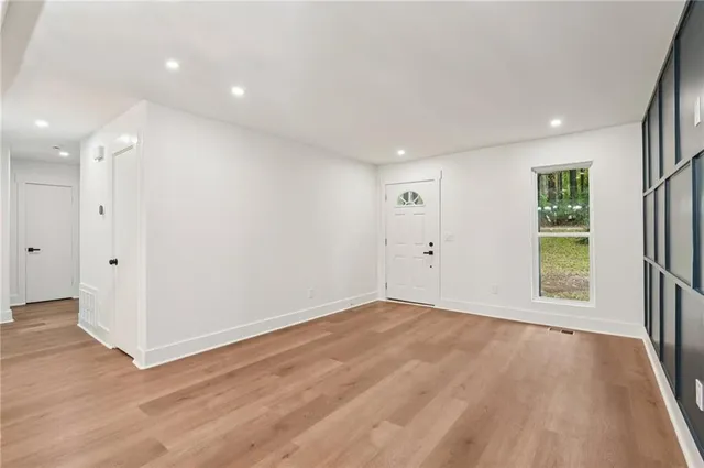 an empty room with wooden floor and windows