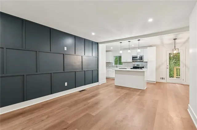 a kitchen with granite countertop a refrigerator and white cabinets