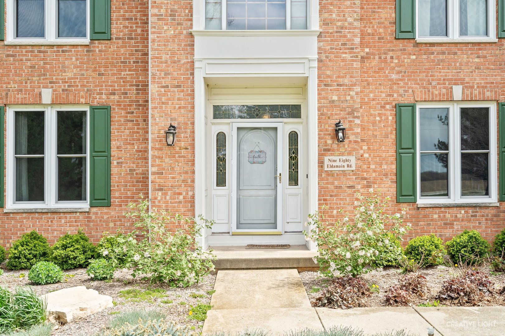 980 Eldamain Road Plano, IL 60545 - Photo 5 of 27 a front view of a brick house with a small yard